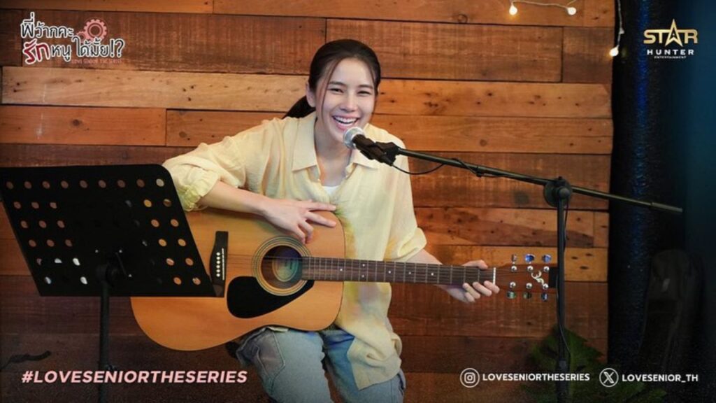 Manaow smiling while singing and playing guitar, in a quiet moment from Love Senior The Series.
