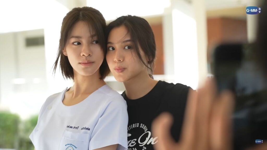 Actress duo from US in behind-the-scenes interaction, symbolizing GL Fandom Drama.