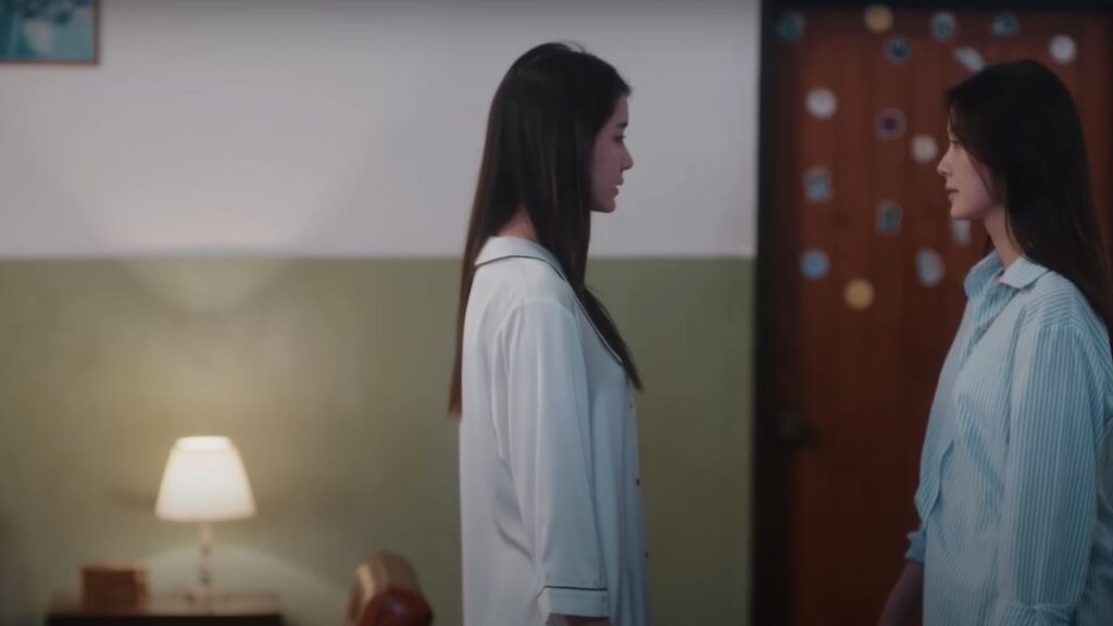 Ai‑oon and Ob‑oom from Pluto Thai TV Series in a tense framed shot, twins marked by distance and identity struggle.