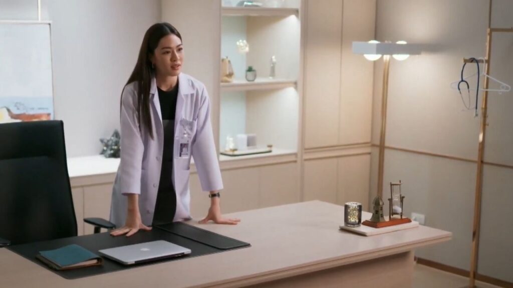 Dr. Fahlada from The Secret of Us Drama Series looking distant in her office, reflecting emotional wounds and protective walls.